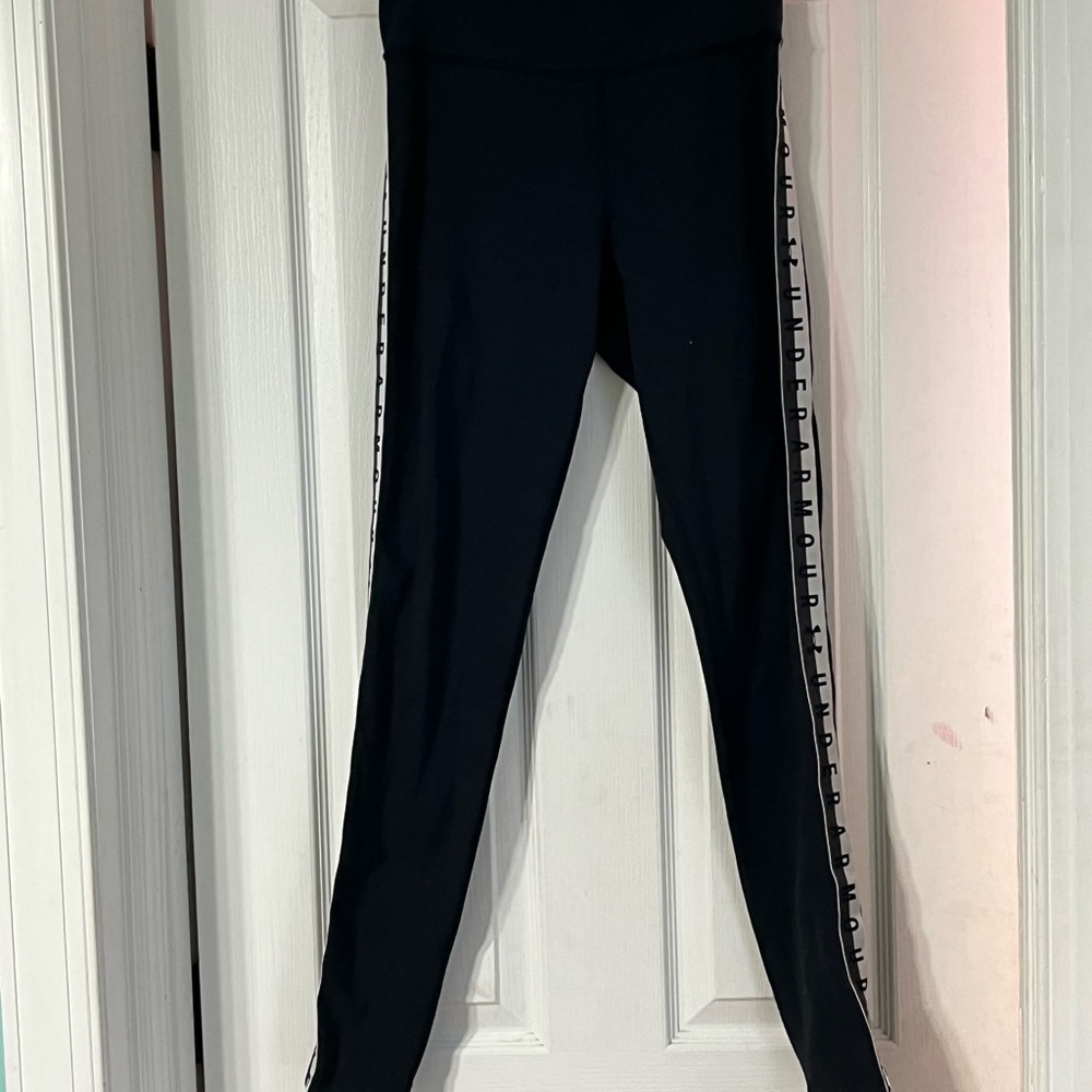 Black under armor leggings with the word under armor down the sides